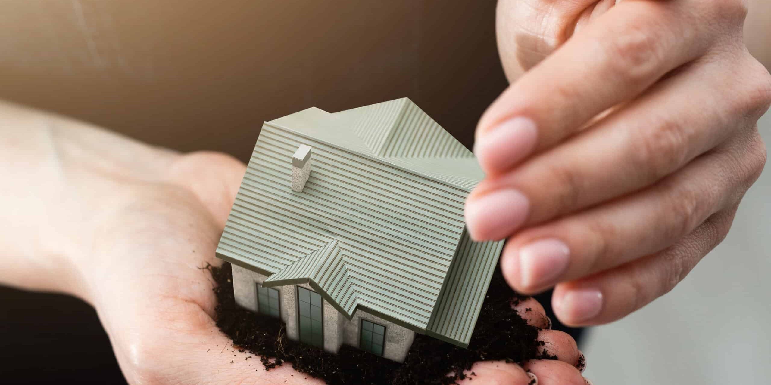 woman hands holding paper house, model.